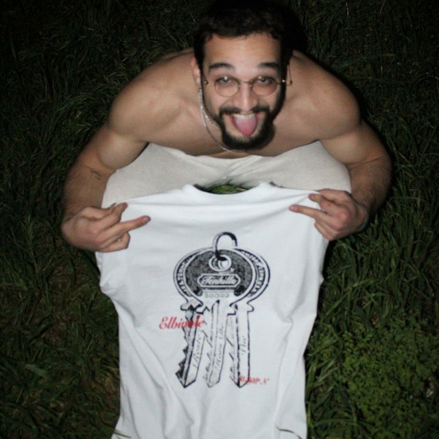 the sta7 cover art: elbivole holding the tee in the grass at night